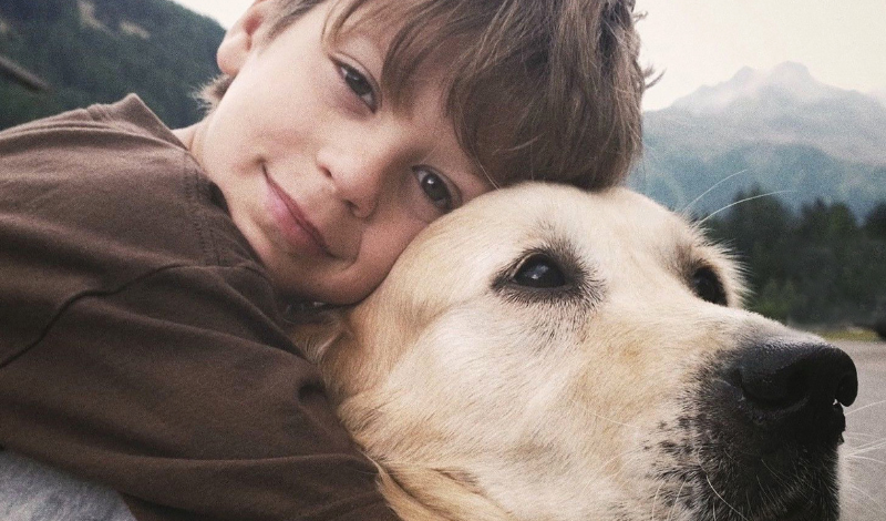 STEINKRAFT Zeolith für Hunde - kleiner Junge umarmt seinem Labrador
