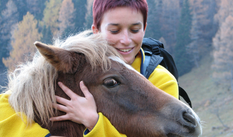 Pferd mit junger Frau naturverbunden
